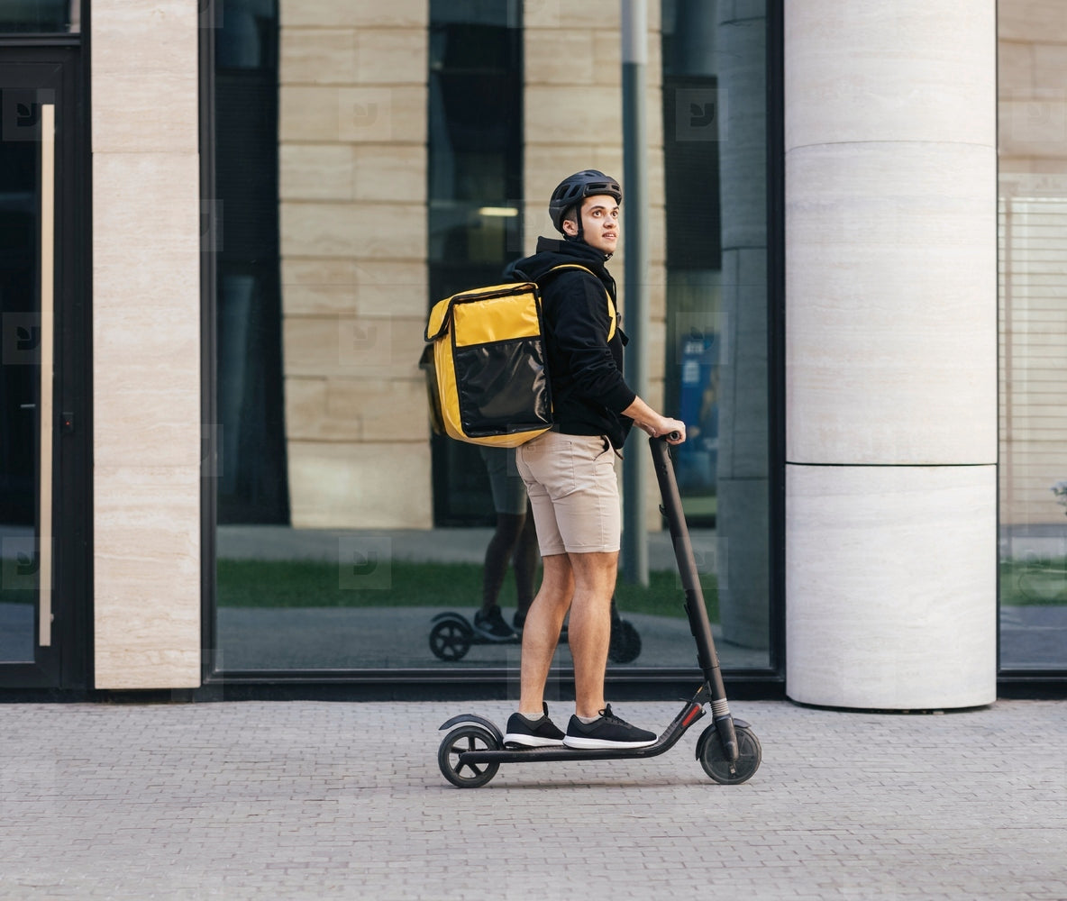 Courier on an electric scooter delivering in the city