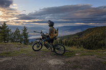 Person standing with the 79BIKE Falcon Pro electric dirt bike on a grassy field