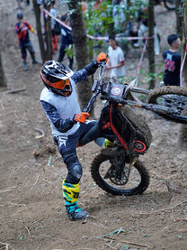Rider jumping with the 79BIKE Falcon Pro electric dirt bike in the forest