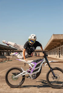Person riding the 79BIKE Falcon Pro electric dirt bike on a footpath