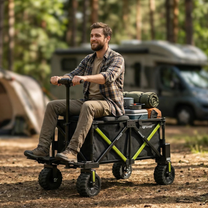 Man sitting on the DYU CampX with luggage at a woodland campsite, motorhome and tent in the background