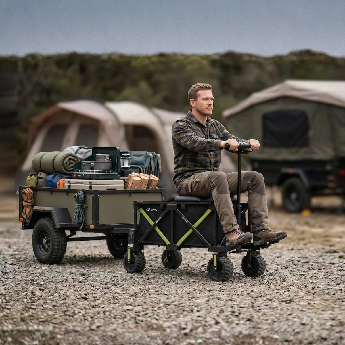 DYU CampX on gravel with a man sitting on the wagon next to a loaded trailer and a tent