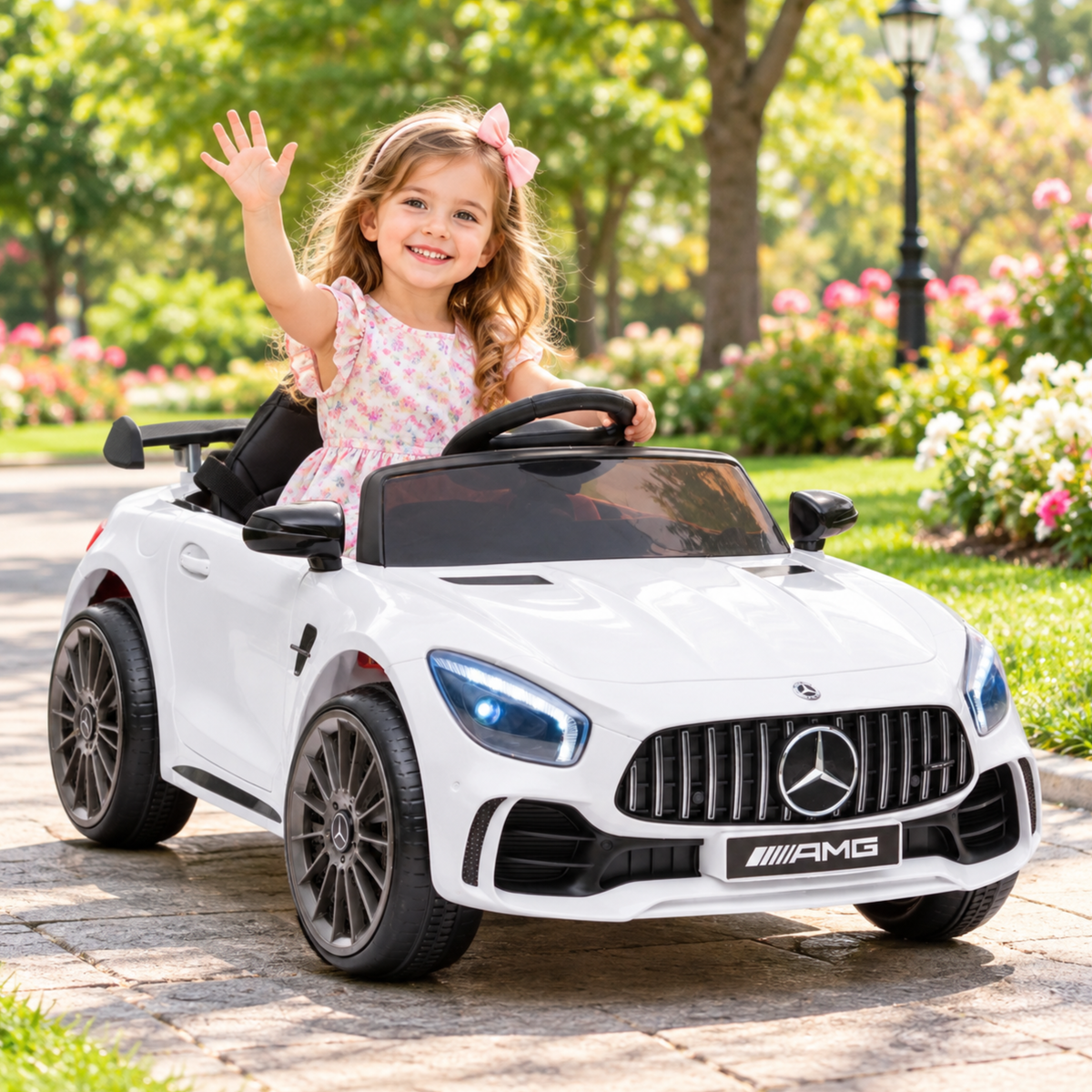Child driving the Mercedes AMG GT electric ride-on car for kids in white in a park