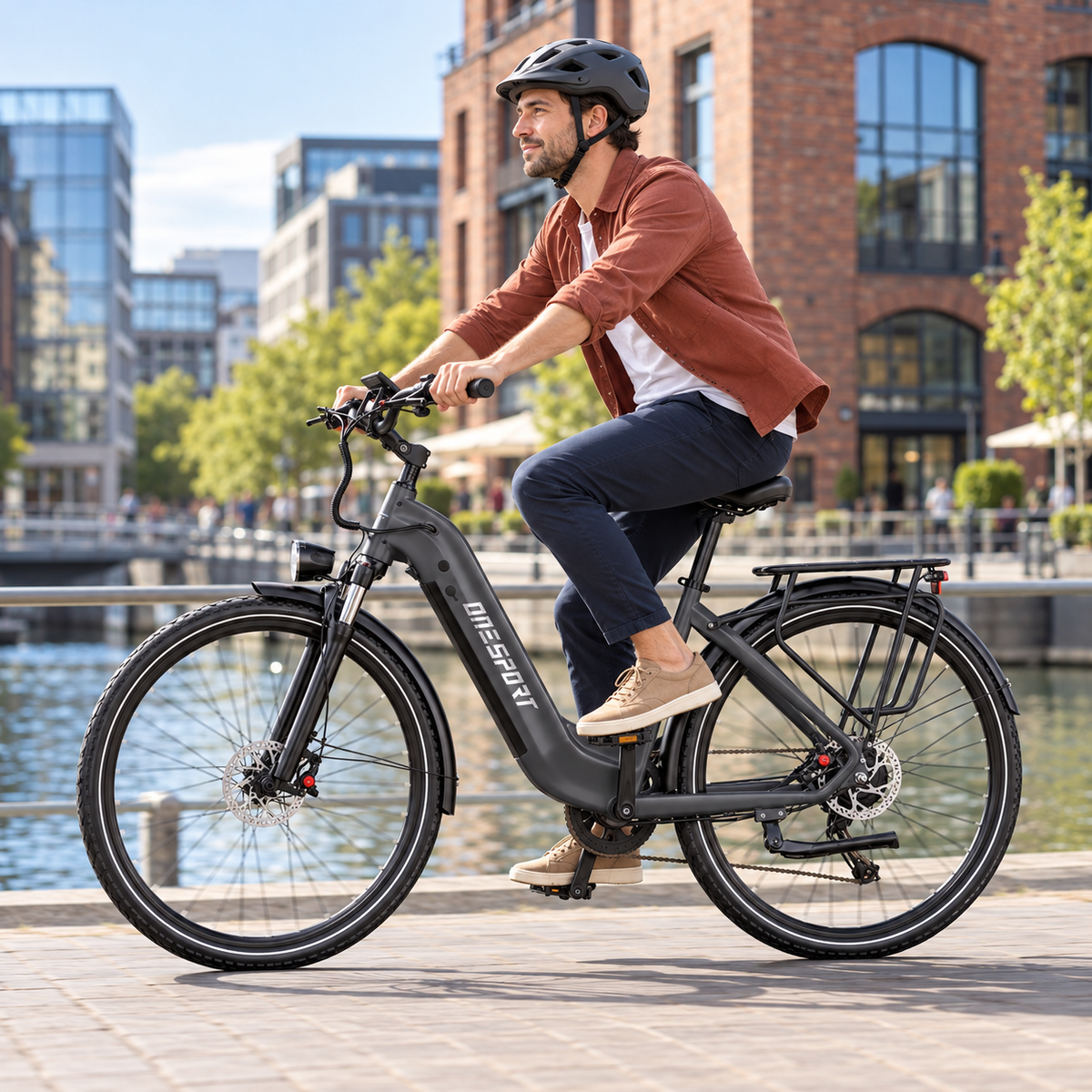 Man wearing a helmet riding a dark grey OneSport OT05 Max along a quay by the water