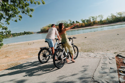 Two people with a OneSport WT05 each by a river, the woman pointing out over the water