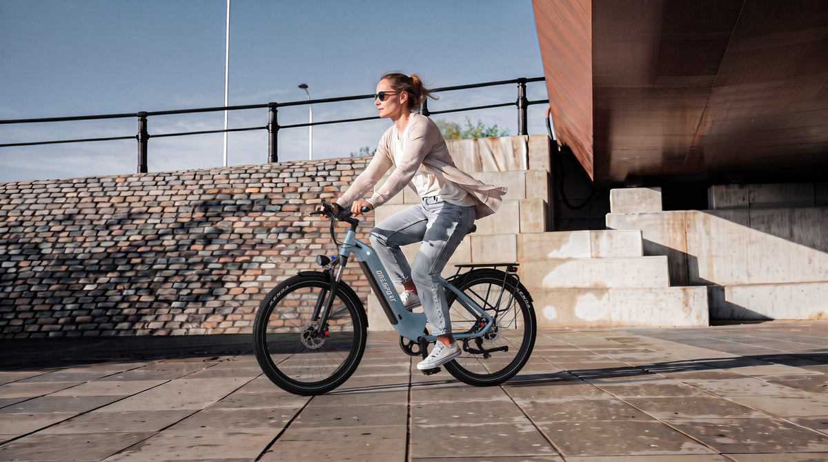 Woman riding OneSport WT05 in side view in front of stone steps and a brick wall