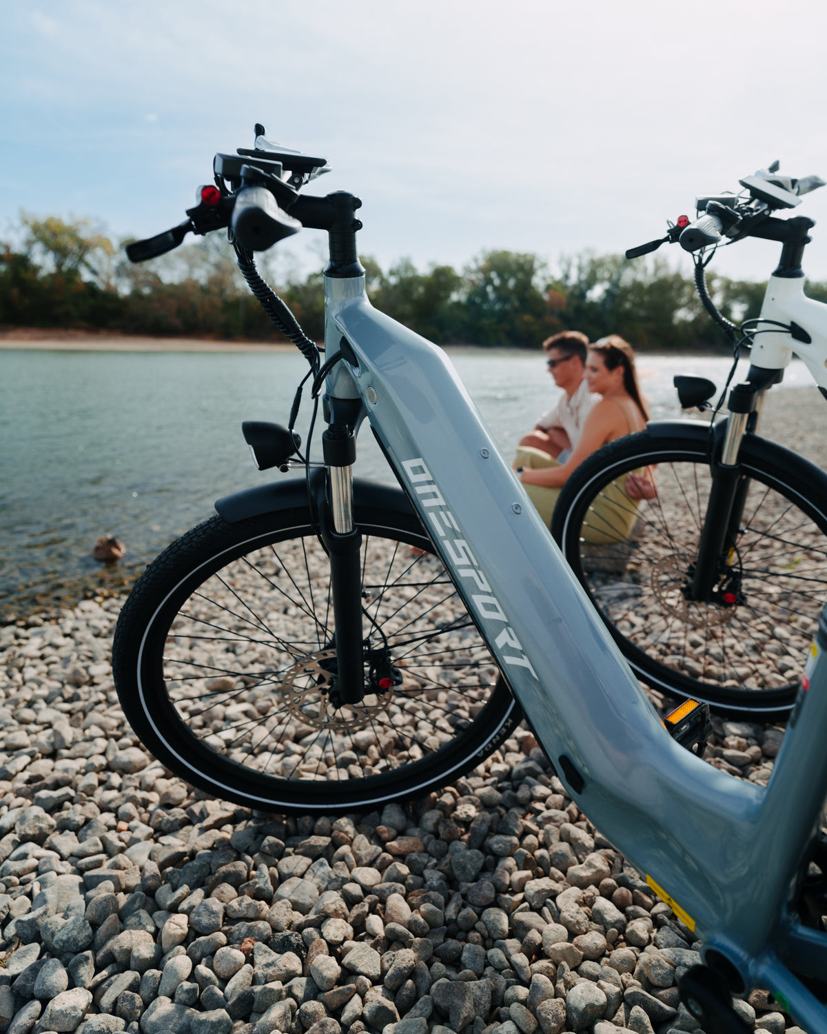 OneSport WT05 on a stony beach by the water with the frame in the foreground and two people sitting in the background
