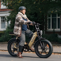 Person riding the TST R7 fat-tyre e-bike in beige on a street