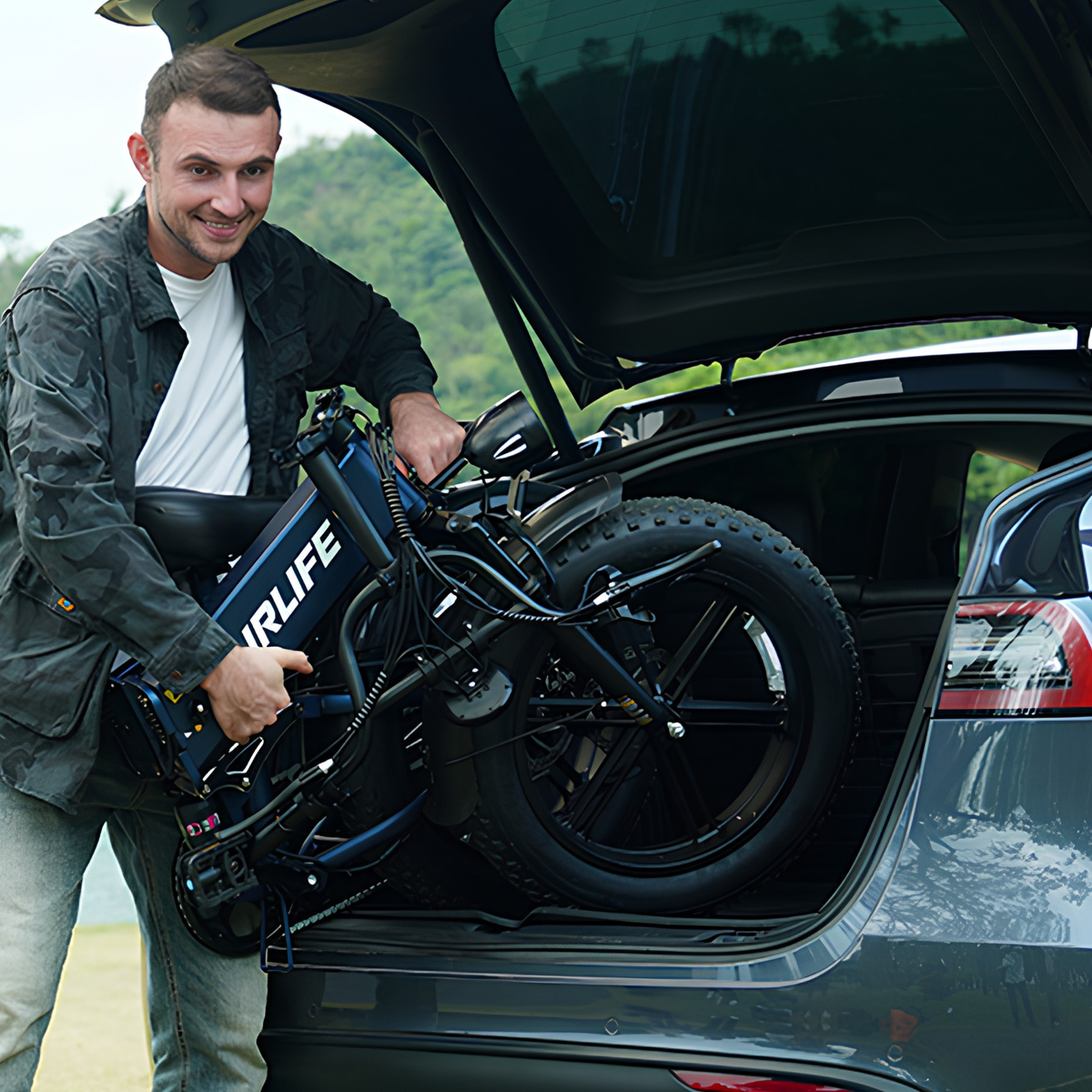 Smiling man loading a folded URLIFE T5 into a car boot