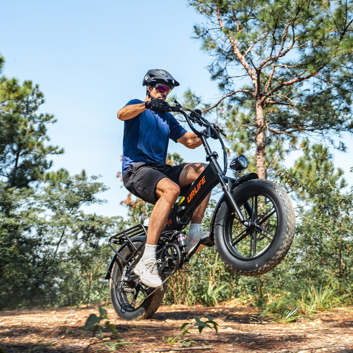 URLIFE T5 with rider on a forest trail, front wheel lifted off the ground