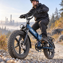 Blue URLIFE T5 with rider on gravel, industrial buildings in the background