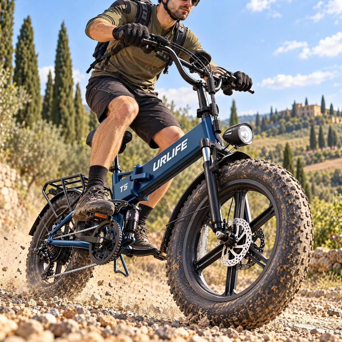 Blue URLIFE T5 fat-tyre e-bike ridden by a man on a gravel road