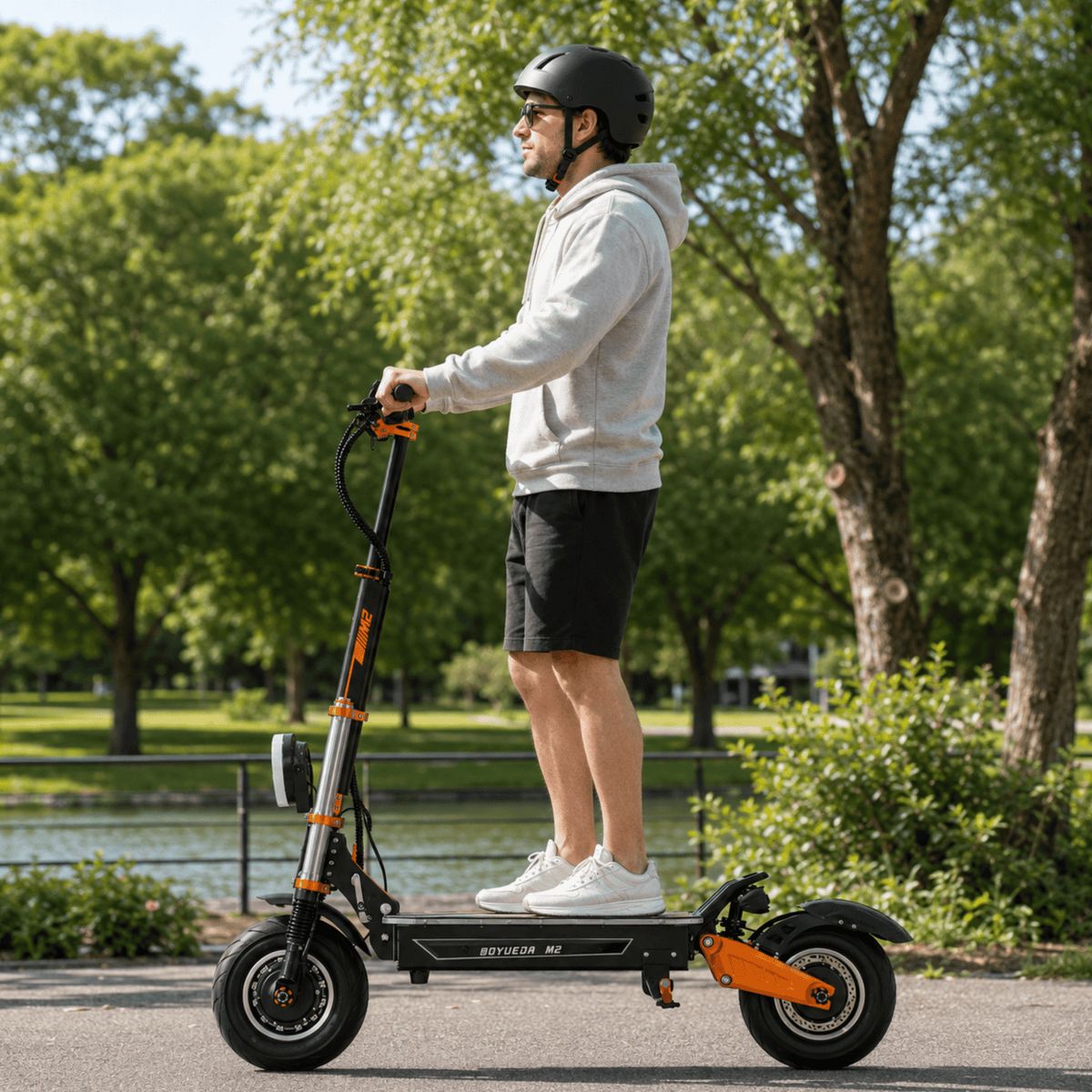 Man standing with the BOYUEDA M2 electric scooter in a park