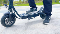 Person riding the DriveTron DT01 electric scooter on a street