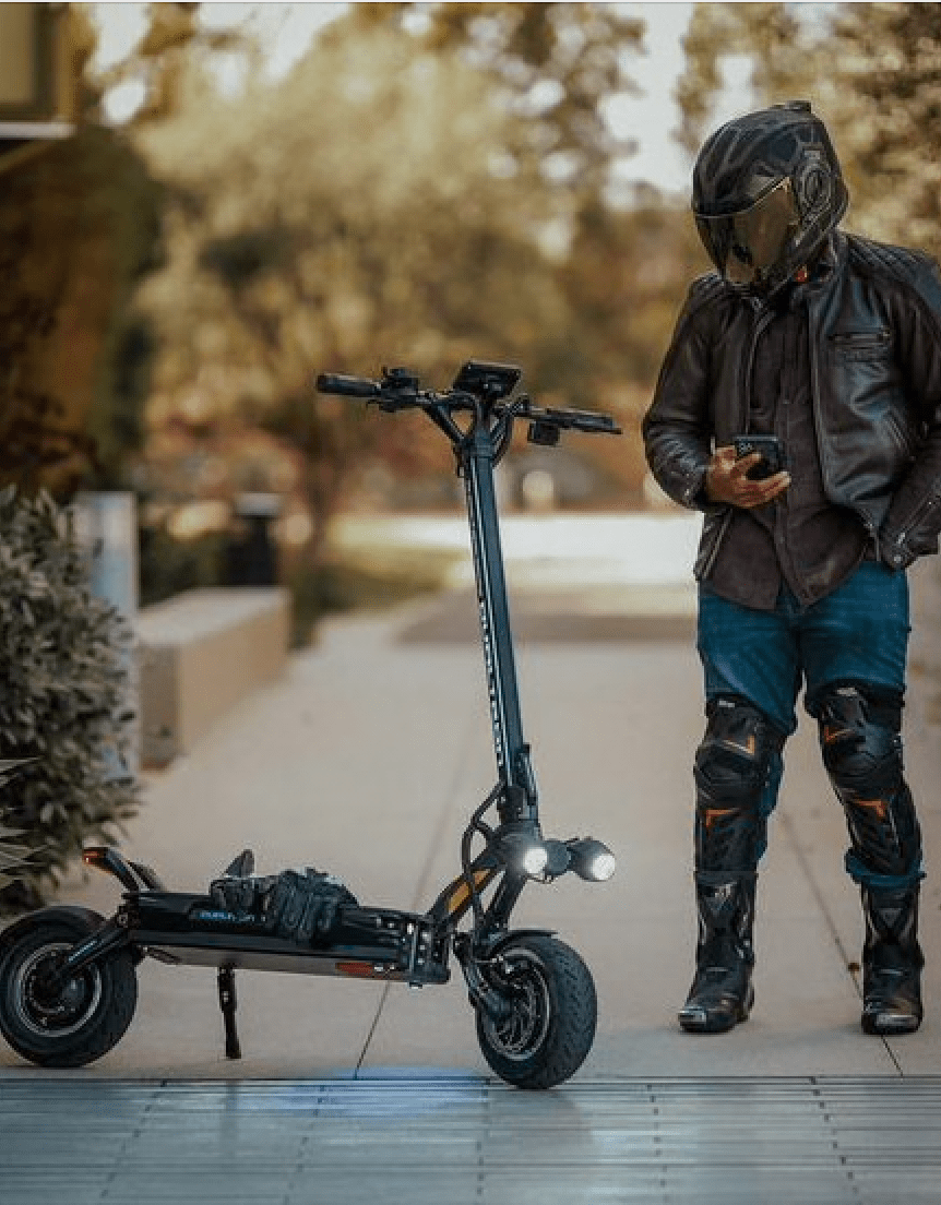 Man standing with the DUALTRON THUNDER 3 electric scooter on a footpath