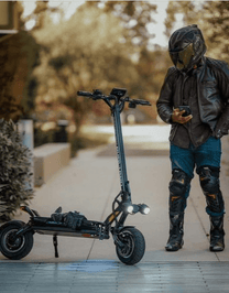 Man standing with the DUALTRON THUNDER 3 electric scooter on a footpath