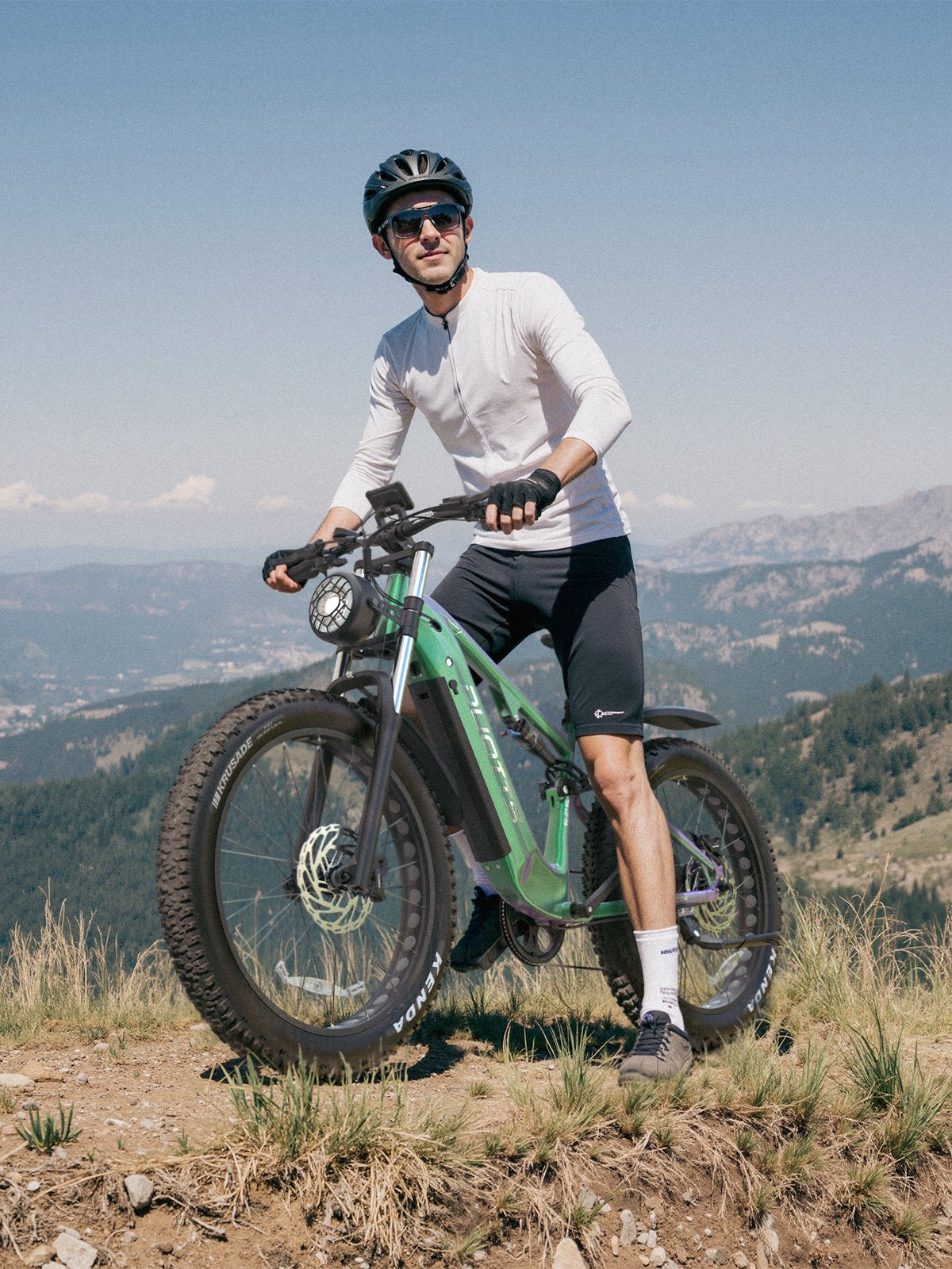 Man standing with the Duotts E26 fat-tyre e-bike on a grassy field