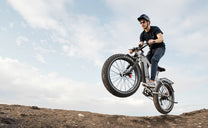 Rider jumping with the Duotts F26 Lite fat-tyre e-bike