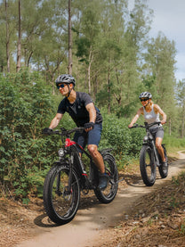 Two riders with the Duotts F26 Lite fat-tyre e-bike in the forest