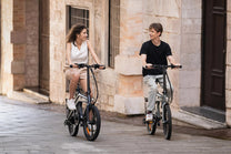 Two riders with the DYU T1 folding e-bike in the city
