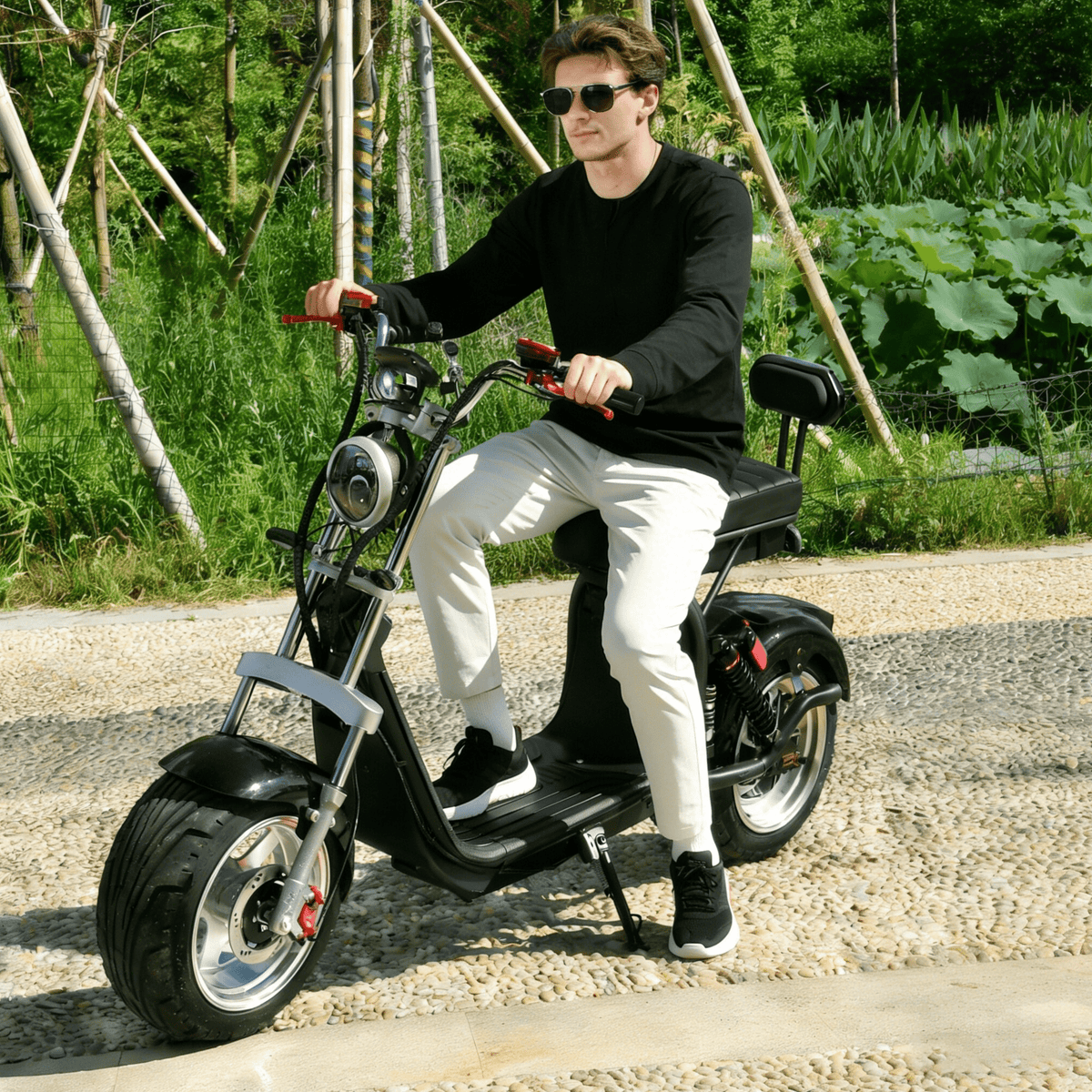 Man riding the eHoodax X10 City Road electric scooter on a gravel road