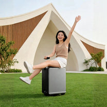 Person sitting on the Air Pro Edition electric ride-on suitcase outdoors