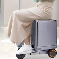 Person riding the Urban Move Edition electric ride-on suitcase in silver indoors