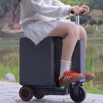 Person riding the Urban Move Edition electric ride-on suitcase in black outdoors