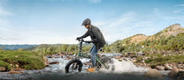 Man riding the ENGWE EP-2 3.0 Boost folding fat-tyre e-bike on a grassy field