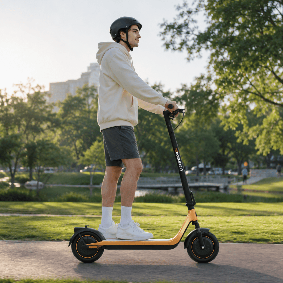 Man standing with the HIKERBOY CURTIS DUAL PRO electric scooter on a grassy field