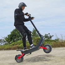 Man riding the HX X10 electric scooter on sandy ground