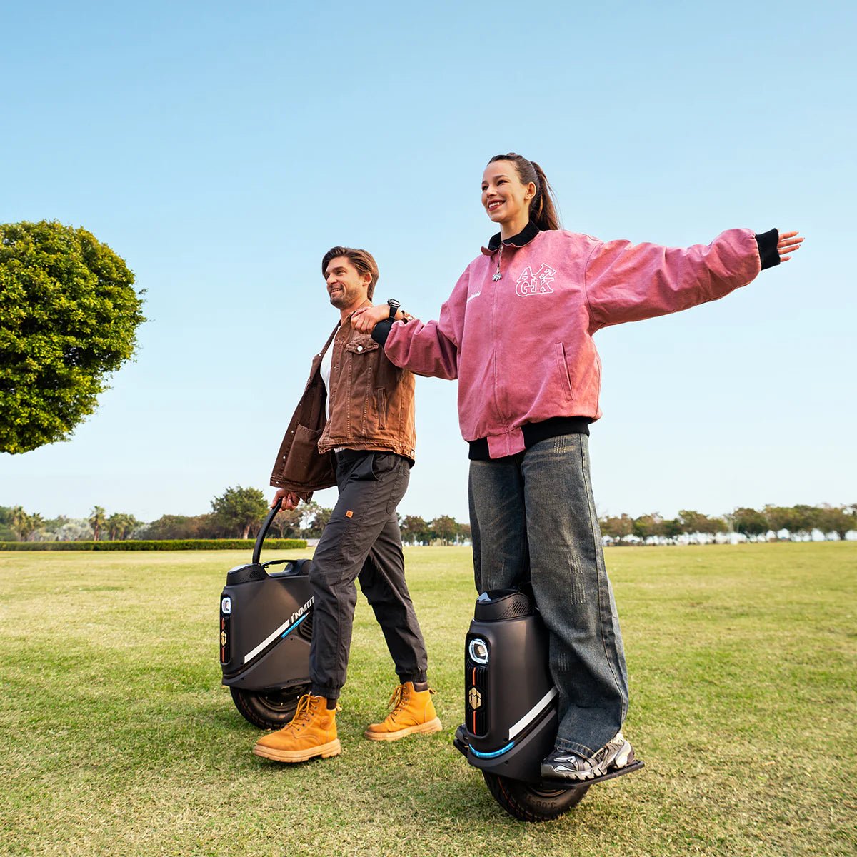 Person riding the InMotion V9 electric unicycle on a grassy field