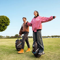 Person riding the InMotion V9 electric unicycle on a grassy field