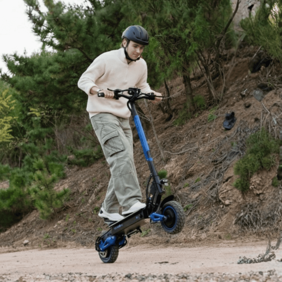 Man riding the KOOLUX U1 Pro electric scooter on a trail