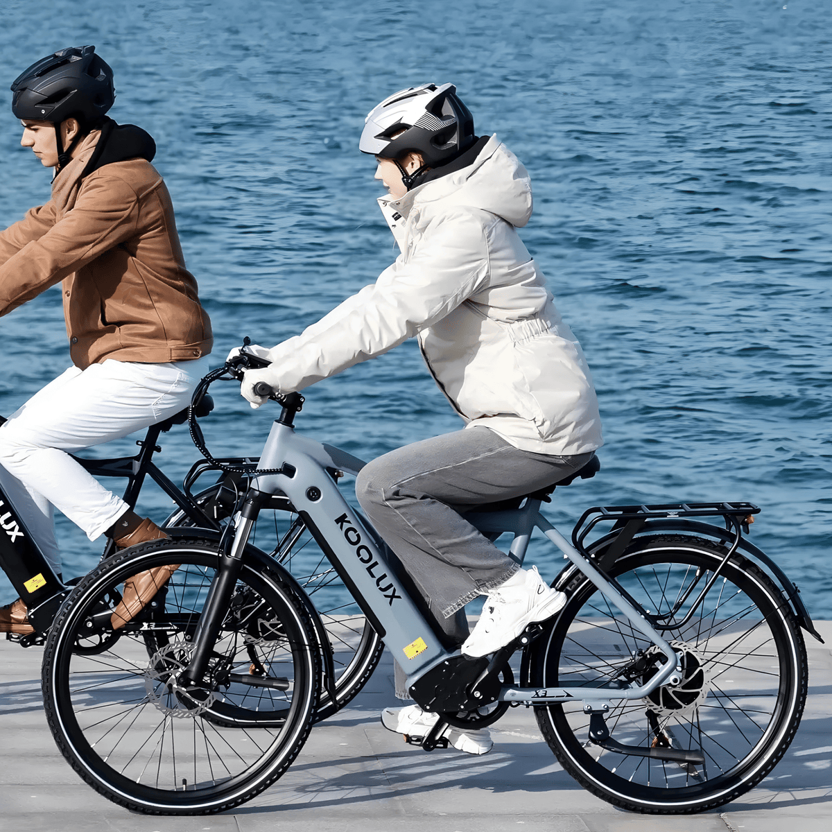 Two riders with the KOOLUX X3 e-bike by the sea