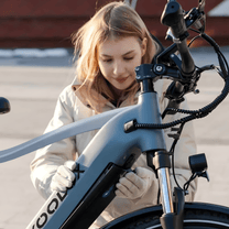 Woman standing with the KOOLUX X3 e-bike in the city