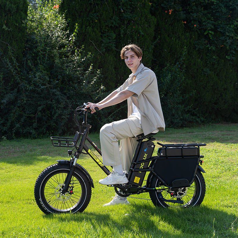 Man riding the KOOLUX X8 fat-tyre e-bike on a grassy field