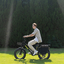 Man riding the KOOLUX X8 fat-tyre e-bike on a grassy field
