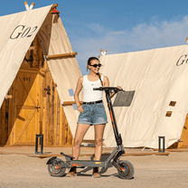 Woman standing with the KuKirin G2 Ultra electric scooter