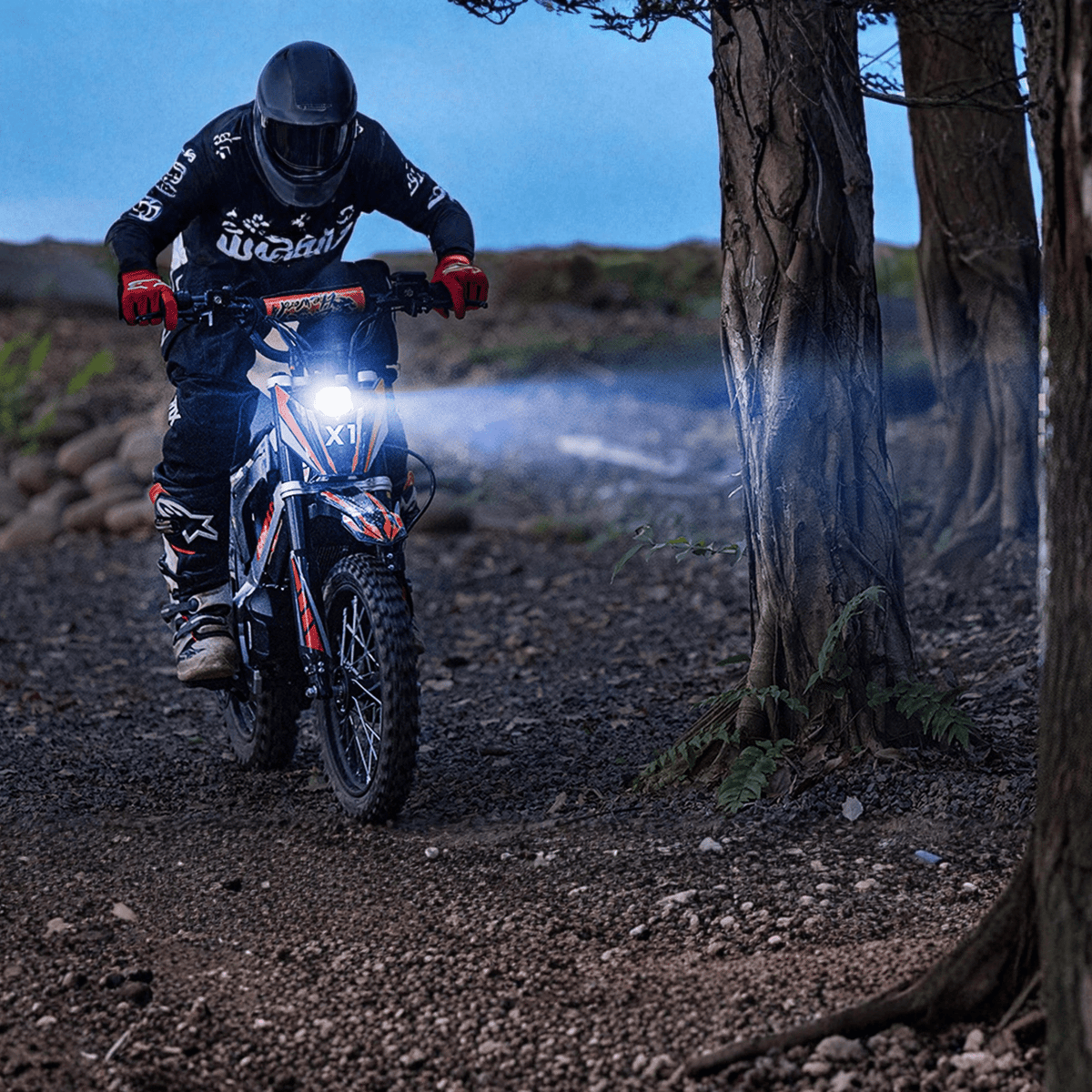 KuKirin X1 electric dirt bike with lights on in an evening setting