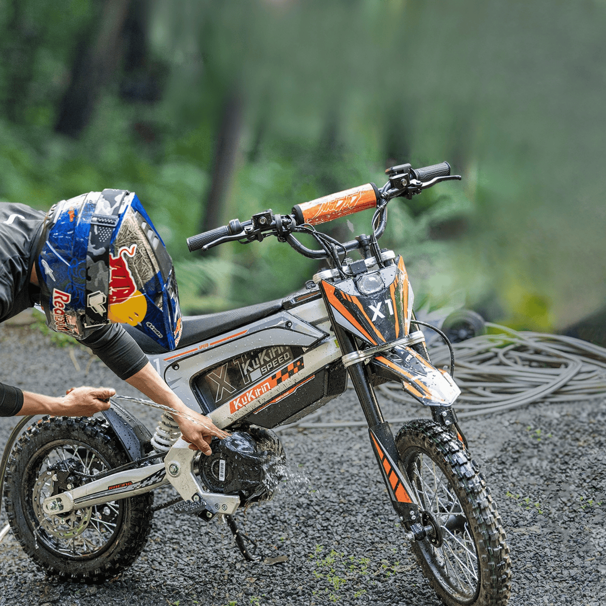 Person standing with the KuKirin X1 electric dirt bike in the forest