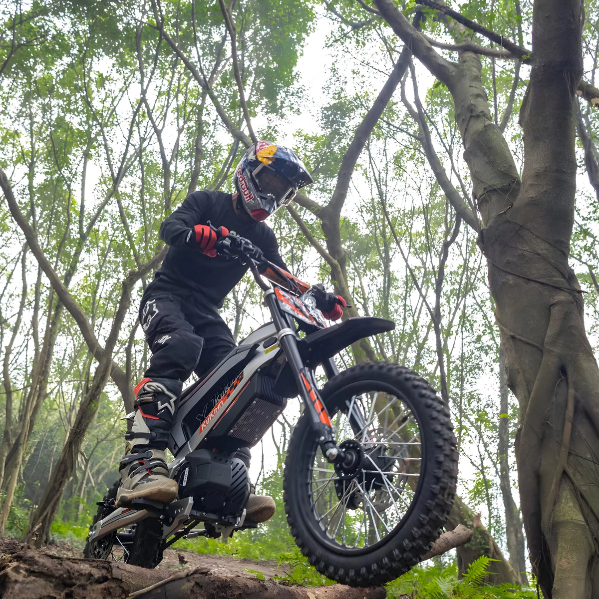 Rider taking the KuKirin X1 electric dirt bike off-road in the forest
