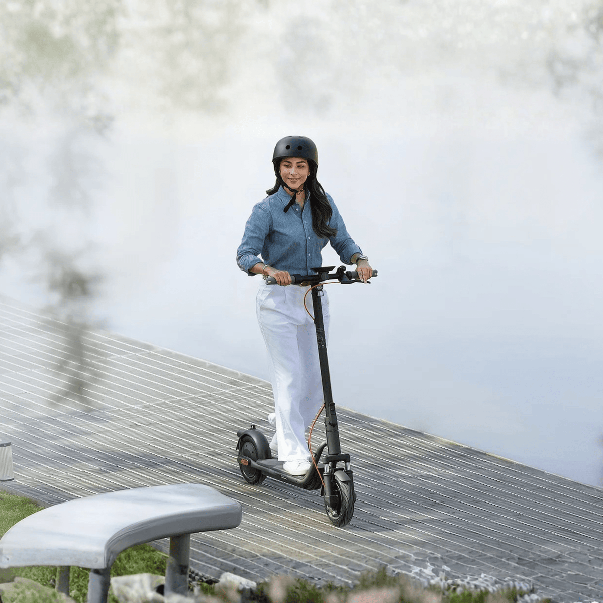 Woman standing with the NAVEE V25i Pro II electric scooter