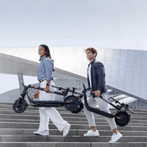 Person carrying the folded NAVEE V25i Pro II electric scooter