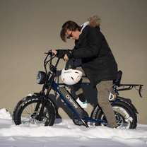 Man standing with the Onemile P40 Pro fat-tyre e-bike wearing a helmet in a winter setting