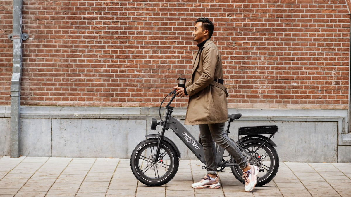 Woman standing with the OneSport OT08 Pro fat-tyre e-bike in grey on a street