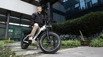 Man riding the OneSport OT08 Pro fat-tyre e-bike in grey in the city