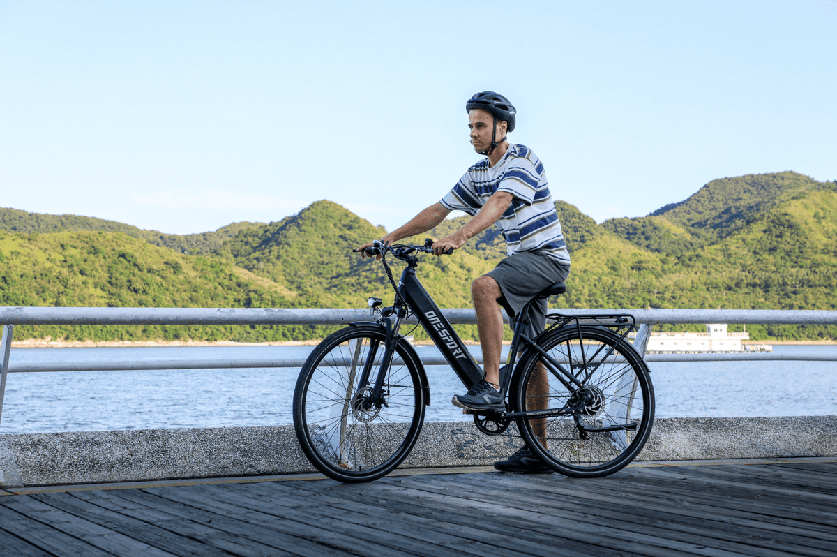 Man sitting on the OneSport OT12 e-bike in black by the sea