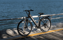 OneSport OT12 e-bike, front three-quarter view in black at sunset