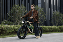 Man standing with the OneSport W66 fat-tyre e-bike on a street